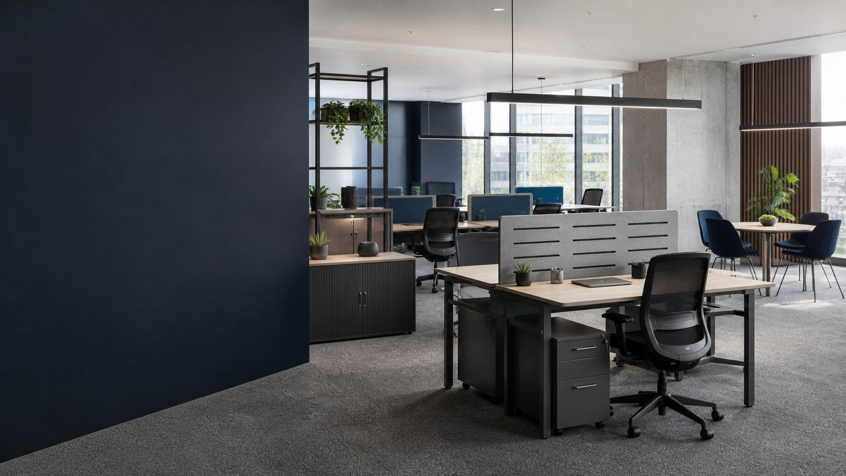 Contemporary commercial workplace furnished with ergonomic chairs, bench desks, acoustic screens, pedestals and collaborative seating